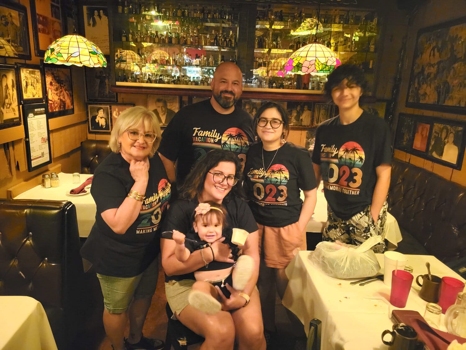 a happy family posing for a group picture inside a restaurant